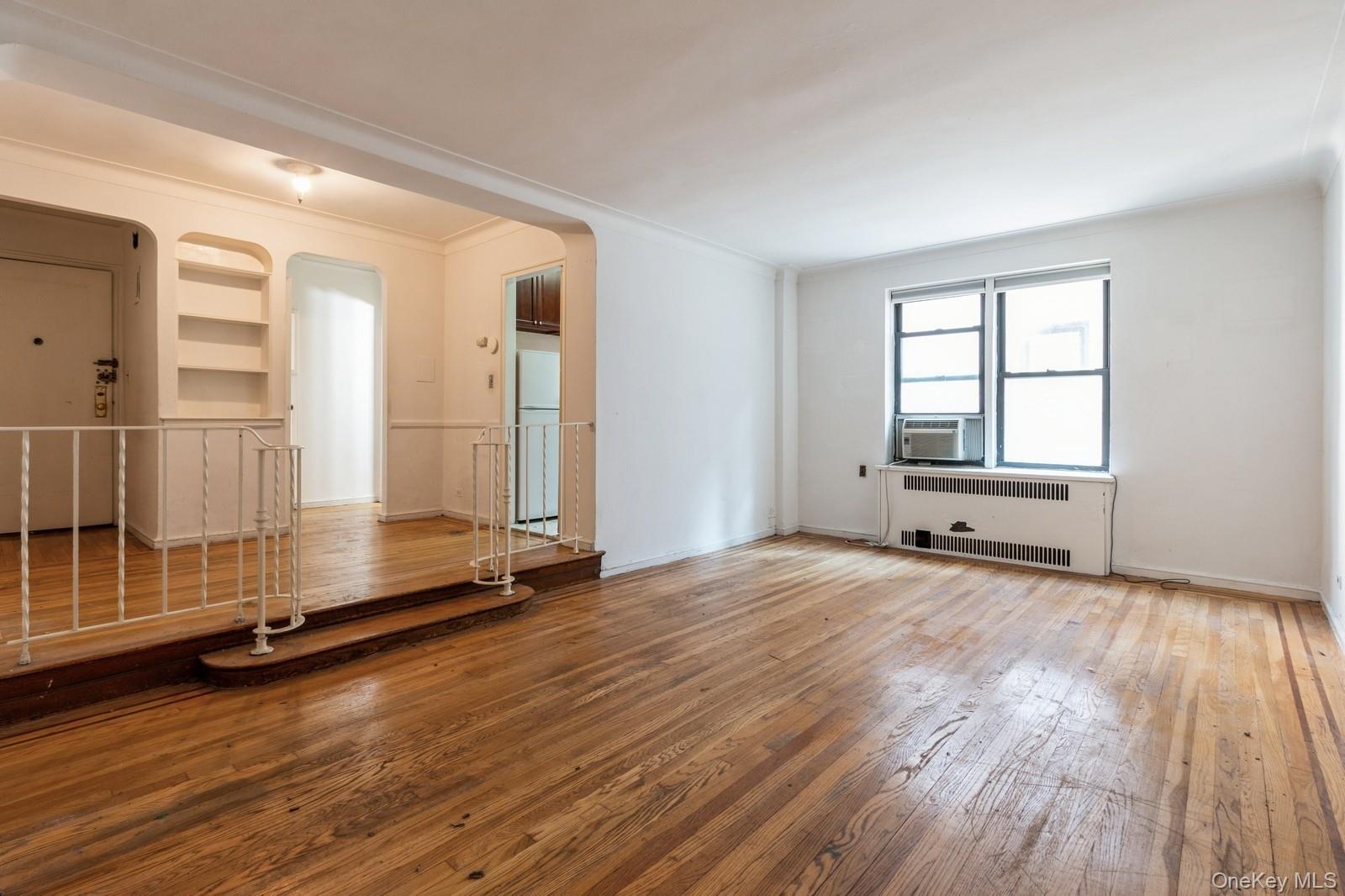 405 West 57th Street, Unit 4C Manhattan, NY 10019 - Photo 8 of 15 an empty room with wooden floor and windows