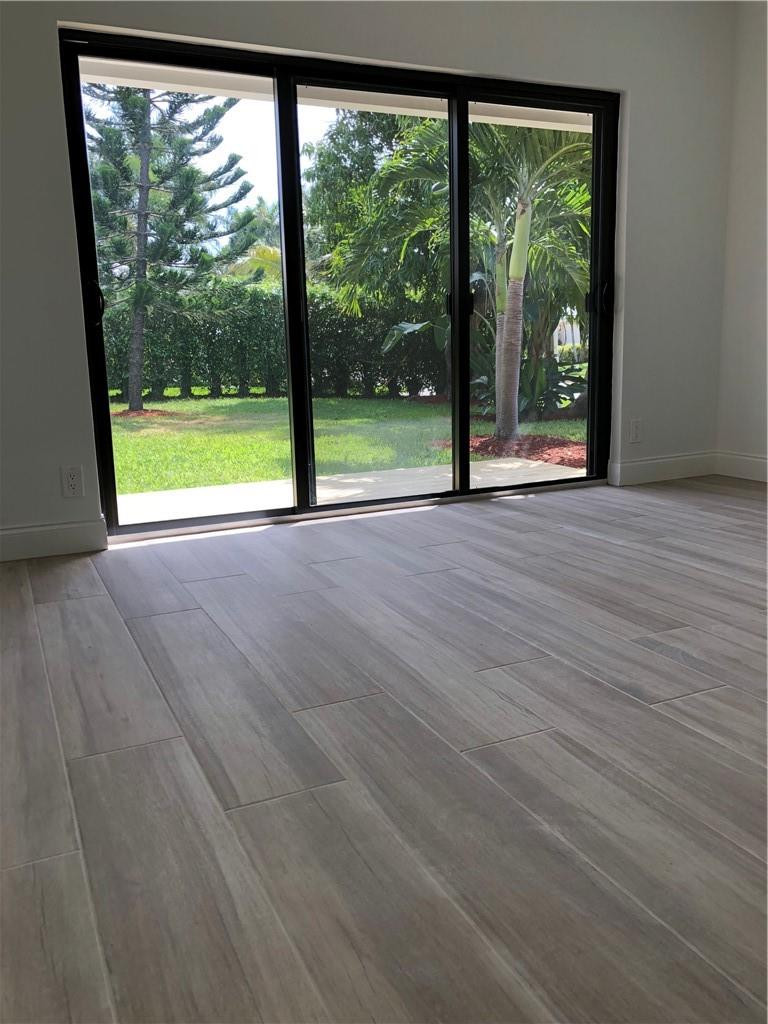 1230 Mulberry Way Boca Raton, FL 33486 - Photo 21 of 31 a view of an empty room with wooden floor and a floor to ceiling window
