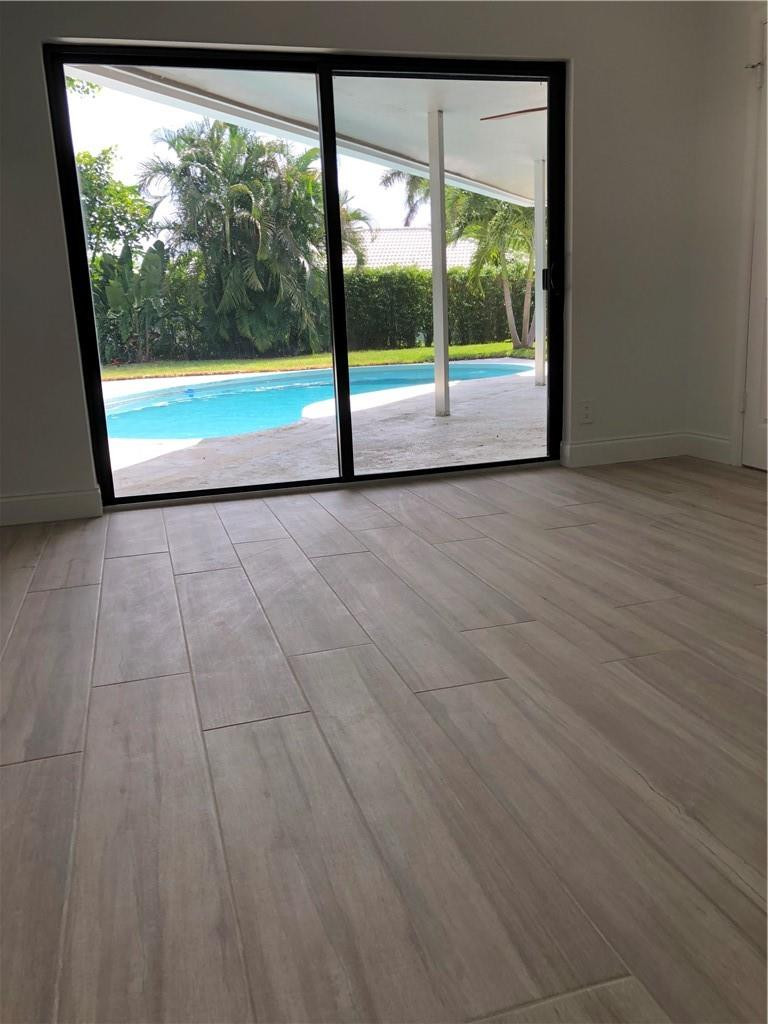 1230 Mulberry Way Boca Raton, FL 33486 - Photo 24 of 31 a view of an empty room with wooden floor and a window