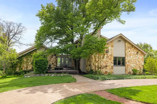 front view of a house with a yard and an trees