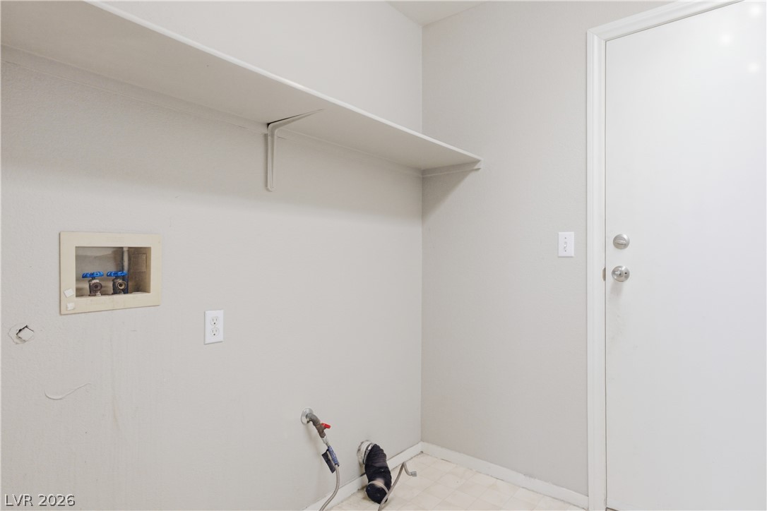 5100 Rancher Avenue Las Vegas, NV 89108 - Photo 21 of 26 A well-organized utility space awaits your personal touch with dedicated appliance hookups and a convenient wall shelf.