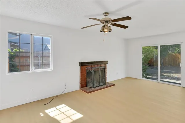 an empty room with a window and a fan