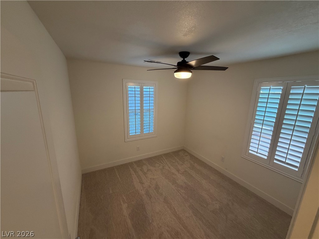 7879 Shoreline Ridge Court Las Vegas, NV 89166 - Photo 20 of 26 Plush carpeting anchors this versatile room detailed with classic plantation shutters.