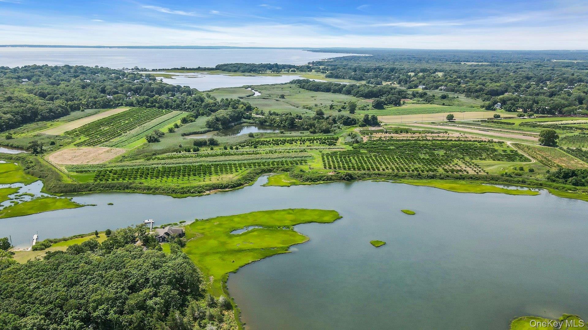 275 Pinewood Road Cutchogue, NY 11935 - Photo 37 of 45 Coastal landscape featuring a large body of water, extensive green areas, and cultivated fields