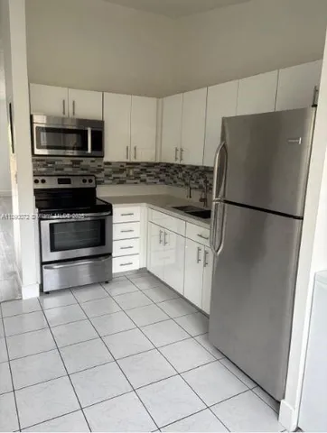 a kitchen with stainless steel appliances a refrigerator sink and microwave