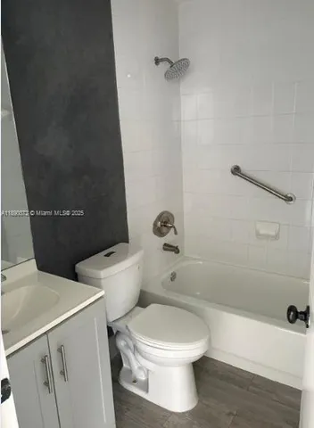 a white toilet sitting next to a bath tub