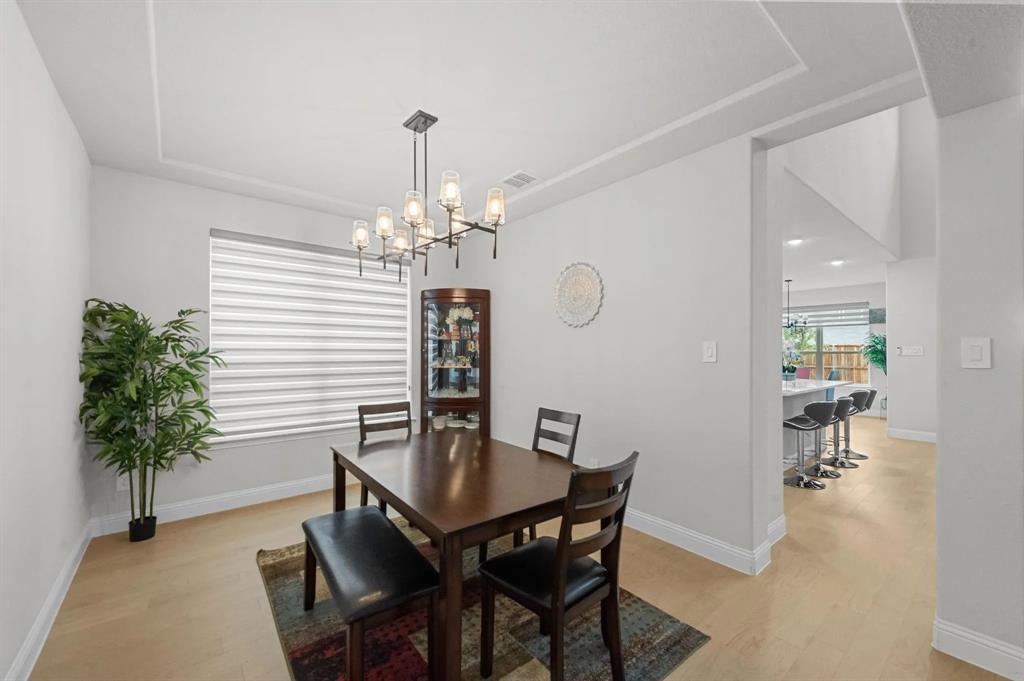 10969 Coastal Violet Road Frisco, TX 75035 - Photo 16 of 30 Dining room featuring light wood-style flooring and a chandelier
