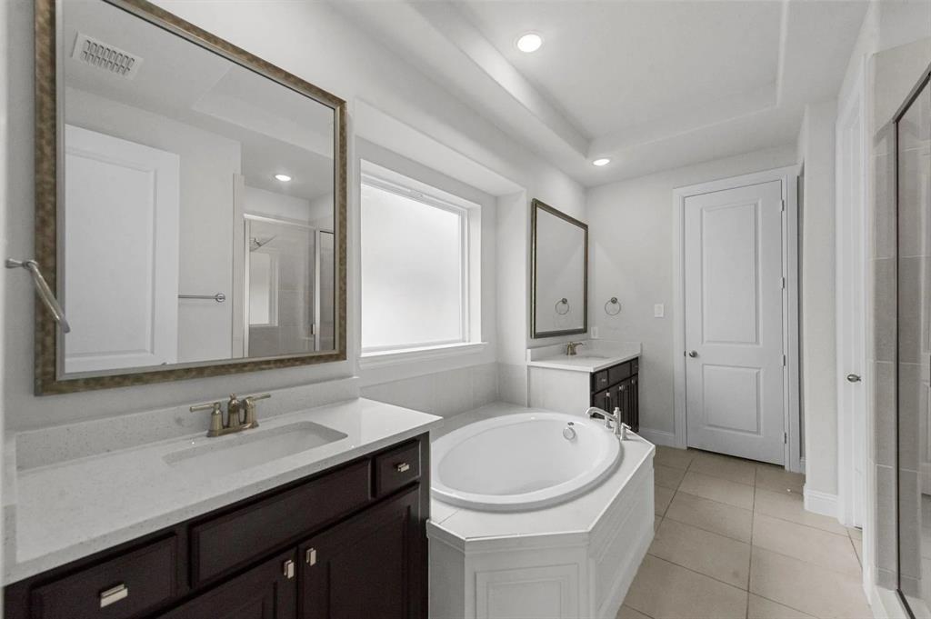 10969 Coastal Violet Road Frisco, TX 75035 - Photo 19 of 30 Full bathroom with a stall shower, two vanities, a garden tub, tile patterned floors, and recessed lighting