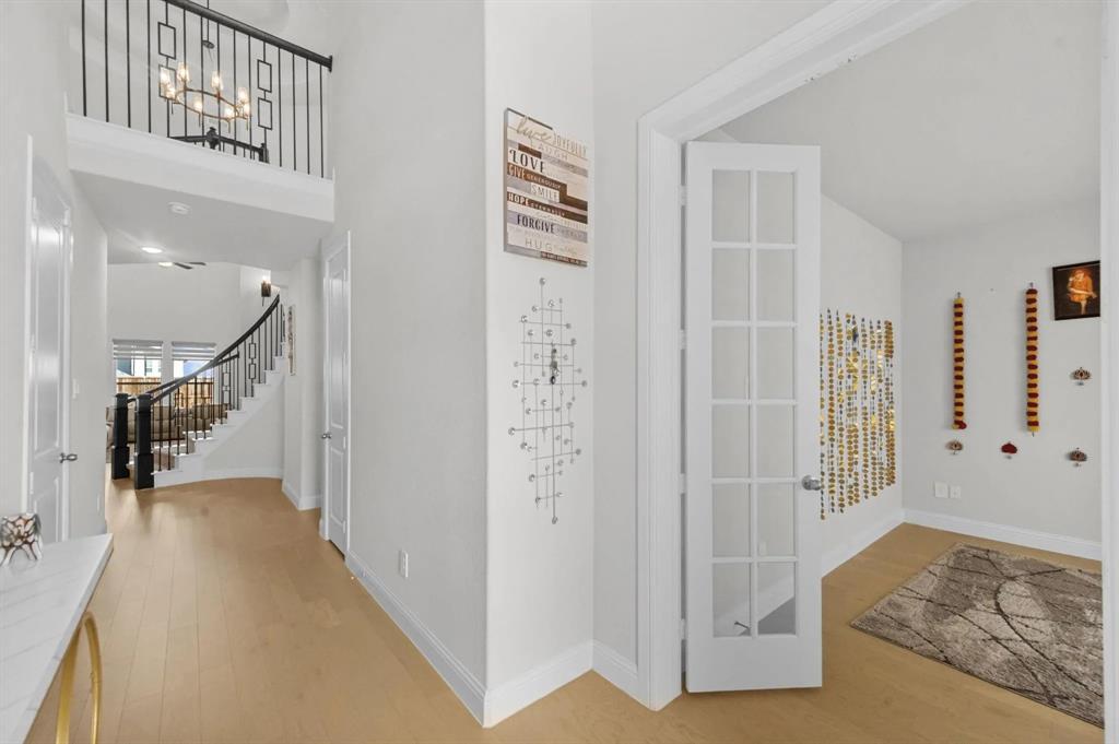 10969 Coastal Violet Road Frisco, TX 75035 - Photo 2 of 30 Entrance foyer with light wood-type flooring, stairway, a chandelier, and a towering ceiling
