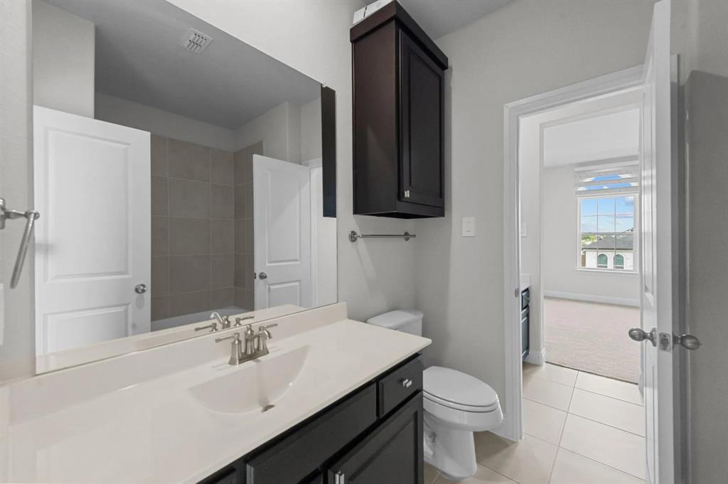 10969 Coastal Violet Road Frisco, TX 75035 - Photo 20 of 30 Bathroom featuring tile patterned flooring, vanity, and a shower