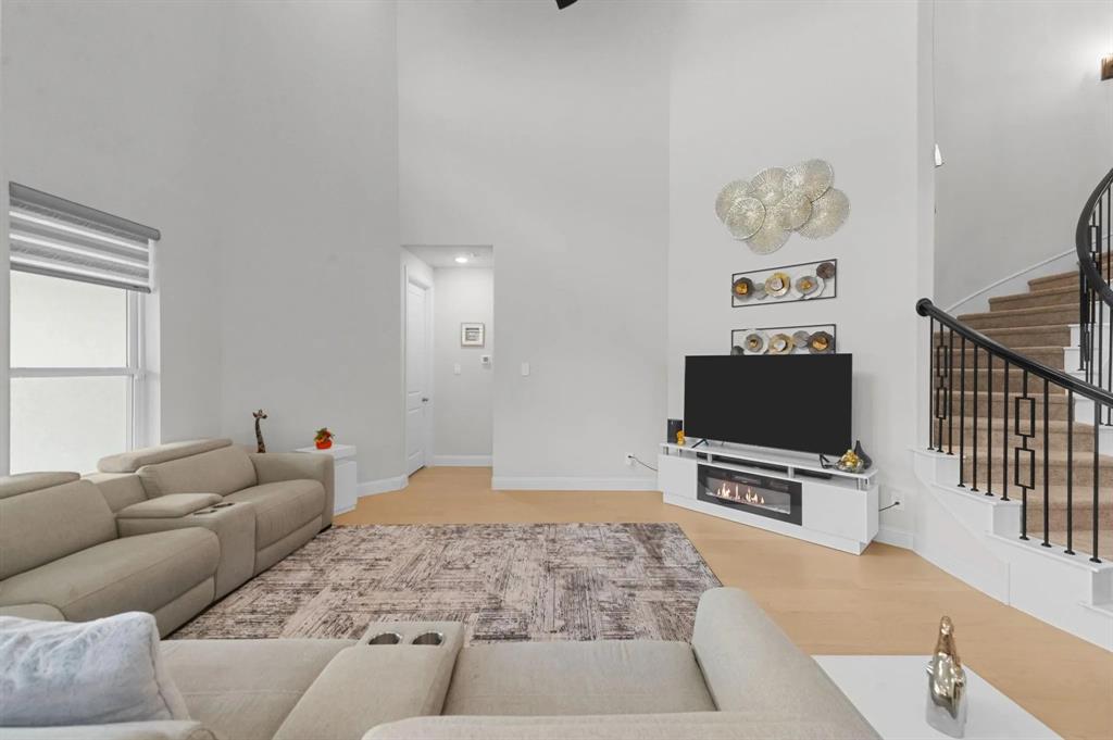 10969 Coastal Violet Road Frisco, TX 75035 - Photo 24 of 30 Living area with stairway, a towering ceiling, and wood finished floors