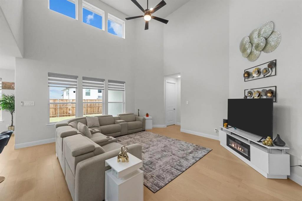 10969 Coastal Violet Road Frisco, TX 75035 - Photo 3 of 30 Living area with a ceiling fan, wood finished floors, and a glass covered fireplace