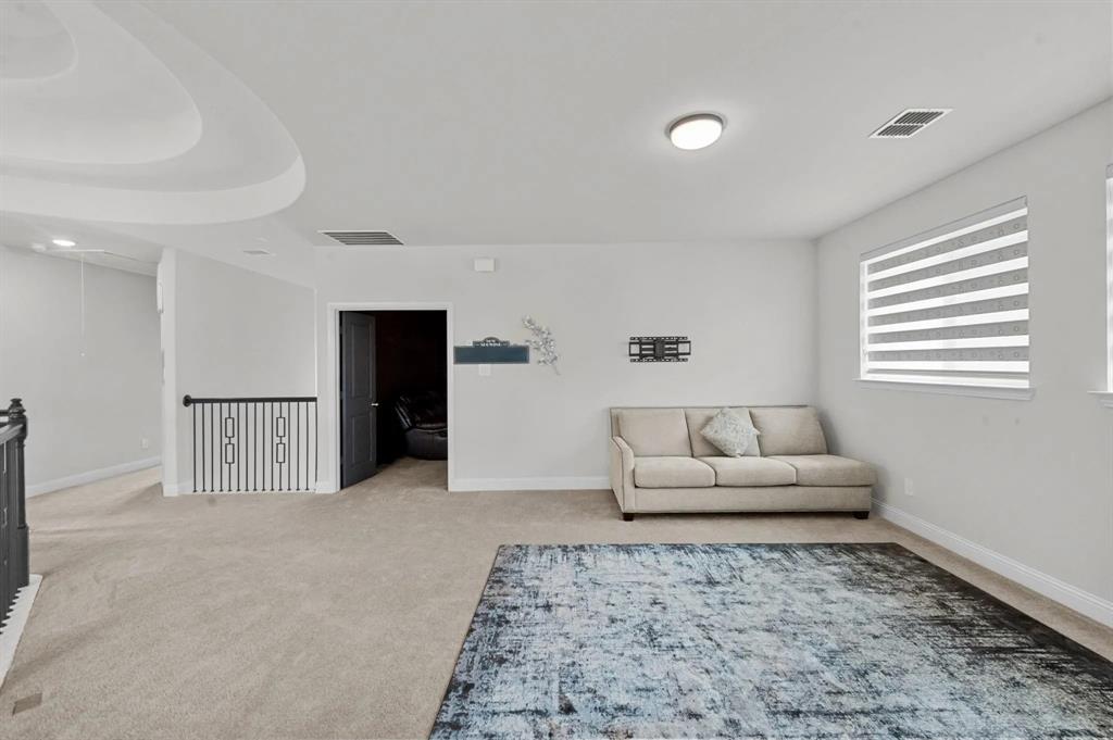 10969 Coastal Violet Road Frisco, TX 75035 - Photo 7 of 30 Living area with carpet floors, an upstairs landing, and attic access