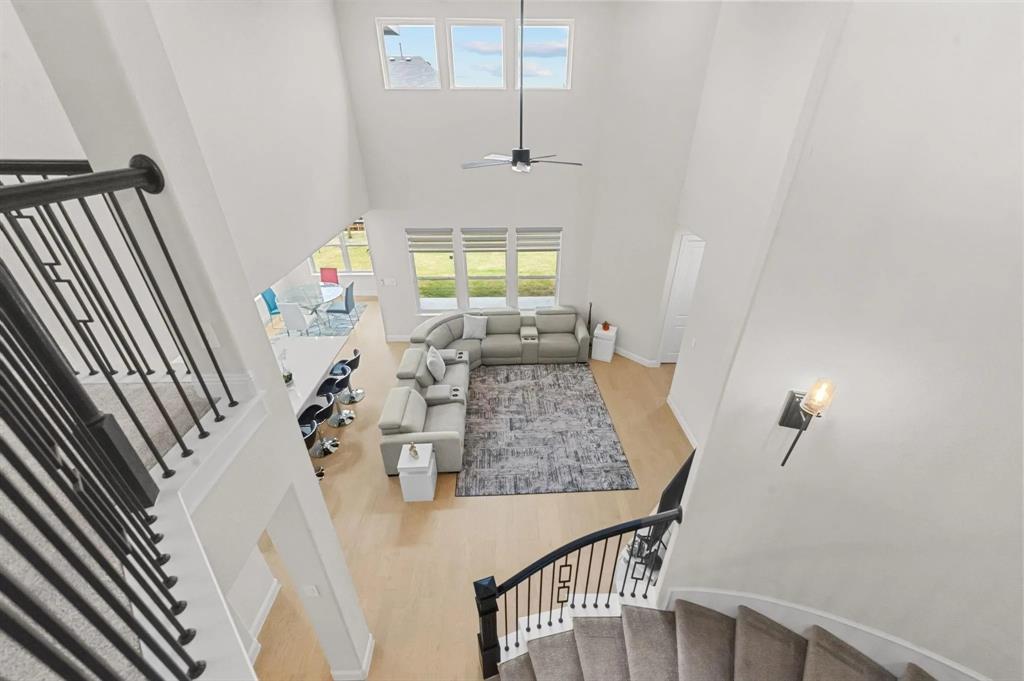 10969 Coastal Violet Road Frisco, TX 75035 - Photo 9 of 30 Stairway with wood finished floors, a towering ceiling, and ceiling fan