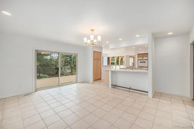 a large white kitchen with a stove a sink dishwasher and a refrigerator with kitchen island