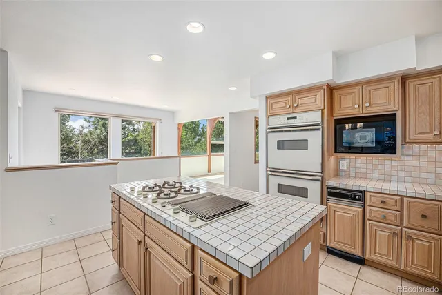 a kitchen with stainless steel appliances kitchen island granite countertop a stove a sink and a microwave