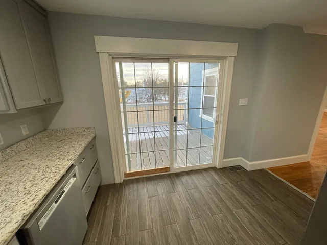 an empty room with wooden floor and entrance