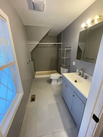 a bathroom with a sink a toilet and shower