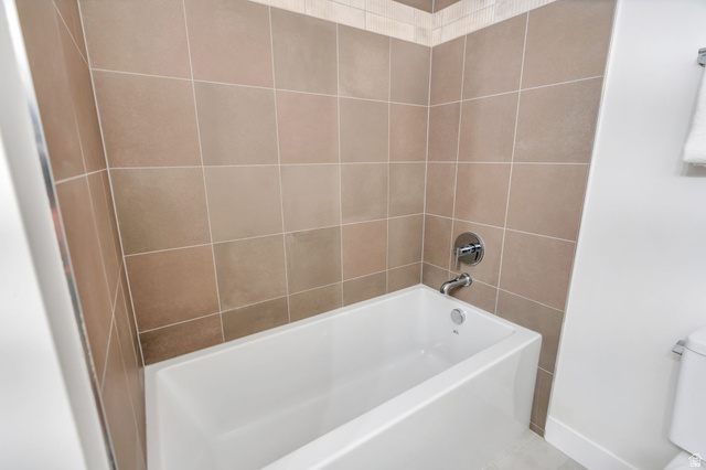 3813 North Foothill Drive Provo, UT 84604 - Photo 29 of 71 Bathtub and shower surround featuring neutral-toned square tiles with a decorative border