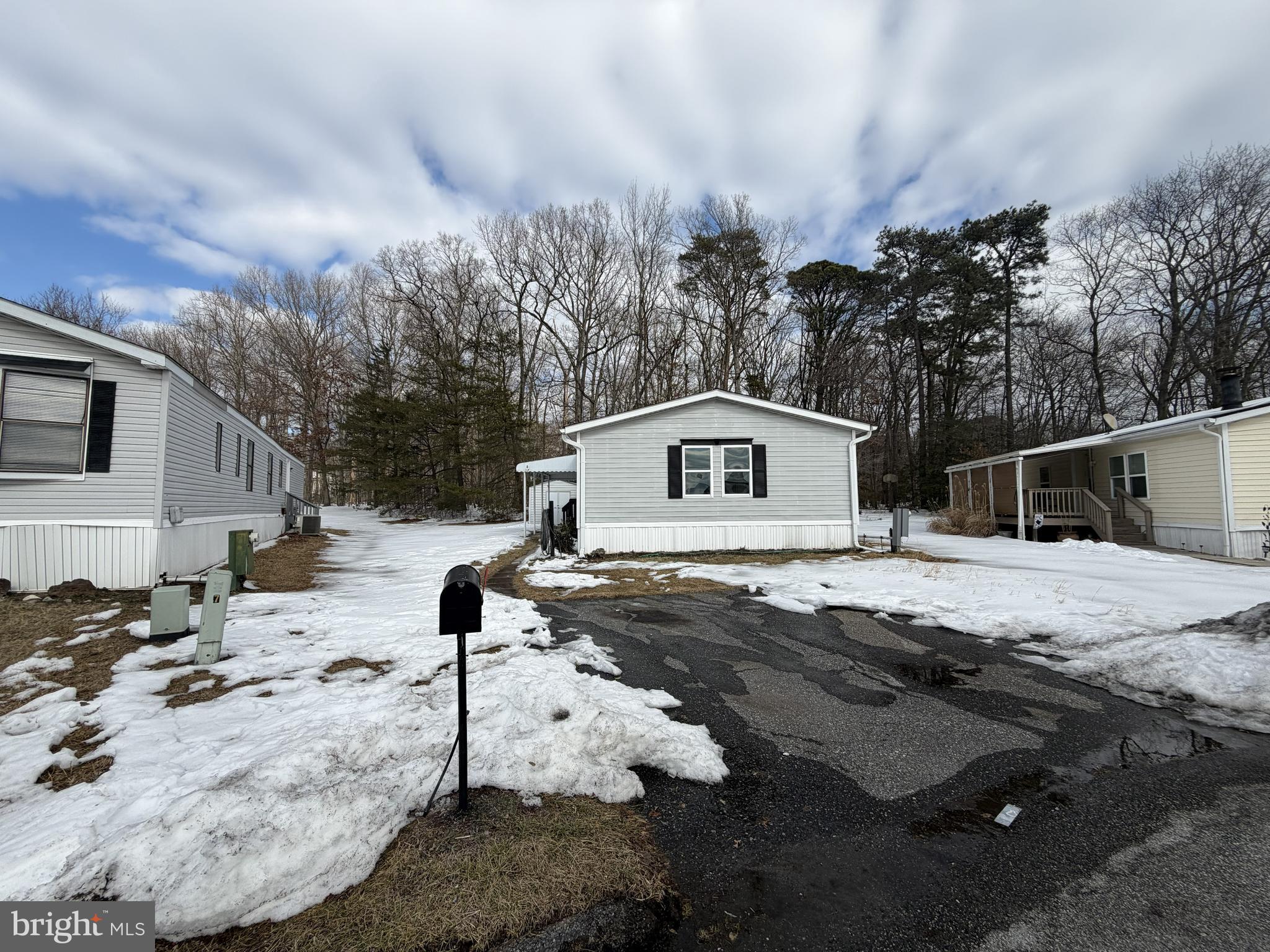 a view of a white house with a yard covered in snow