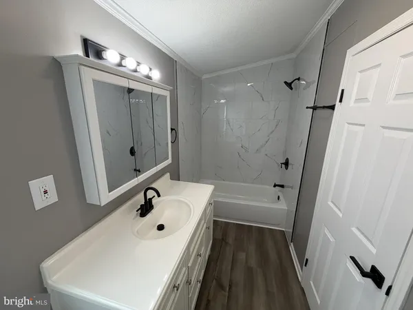 a bathroom with a tub a sink and mirror