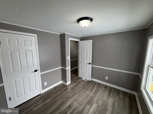 an empty room with wooden floor and entrance