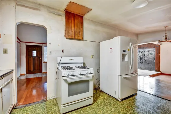 a kitchen with a stove a refrigerator and a more cabinets