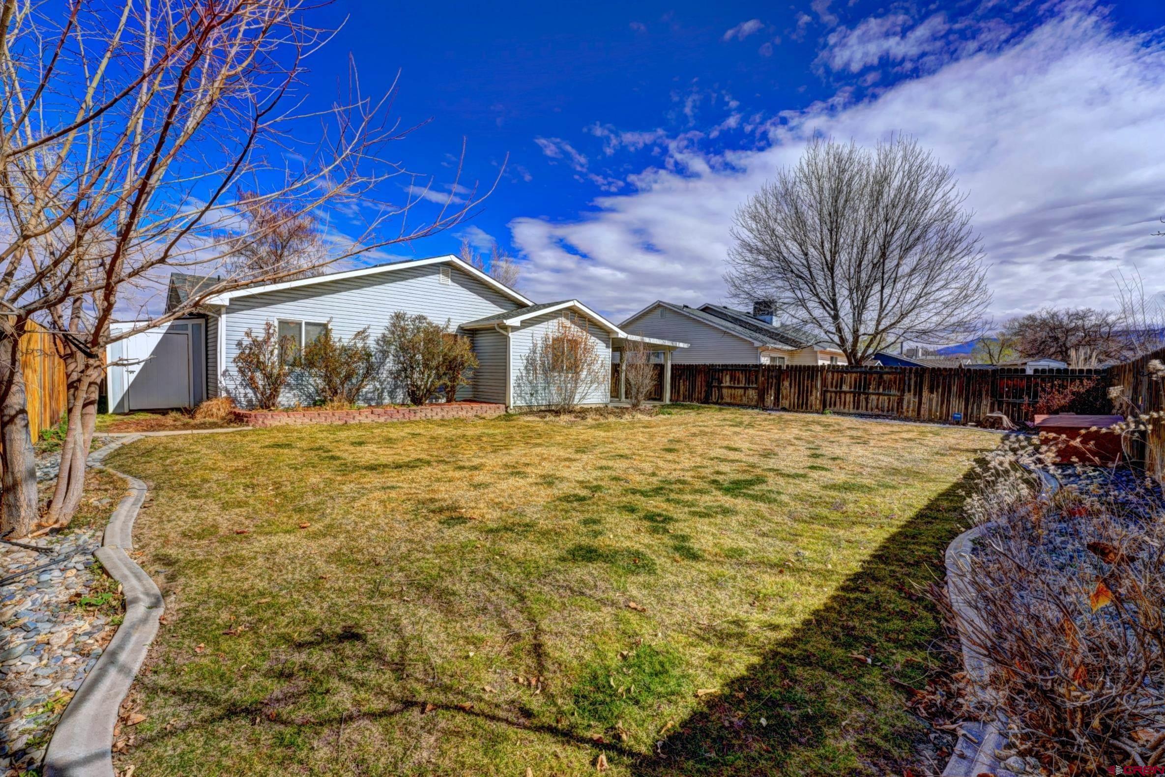 3119 D 3/4 Road Grand Junction, CO 81504 - Photo 27 of 31 a view of a white house with a yard