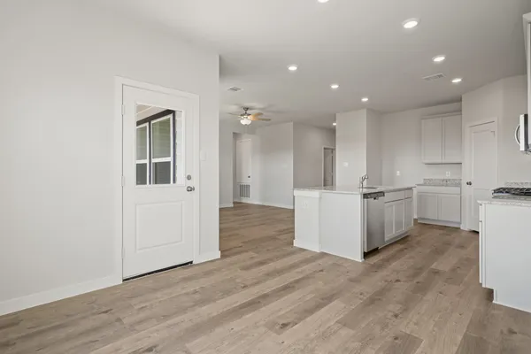 a view of a kitchen with white cabinets and wooden floor