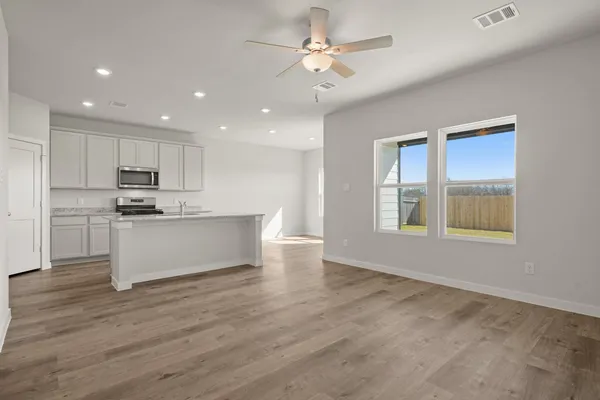 a view of kitchen with granite countertop cabinets and window