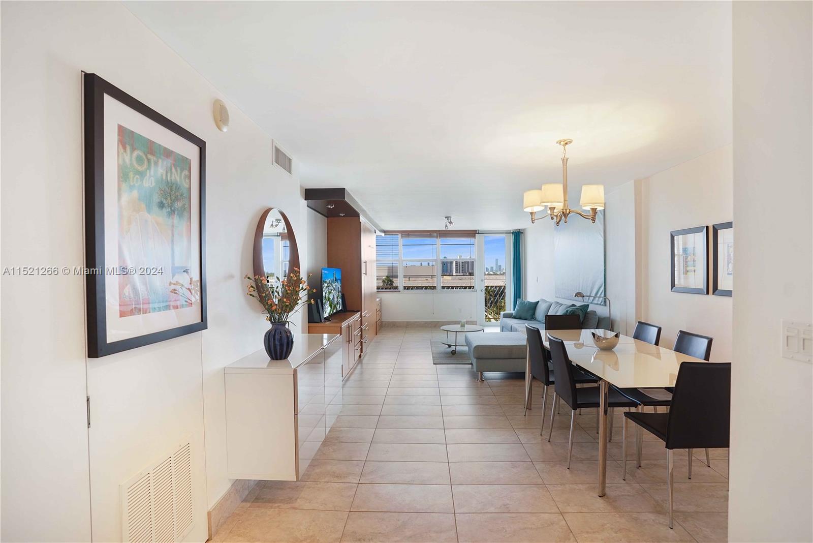 245 18th Street, Unit 902 Miami Beach, FL 33139 - Photo 18 of 54 a living room with furniture a chandelier and a painting on the wall