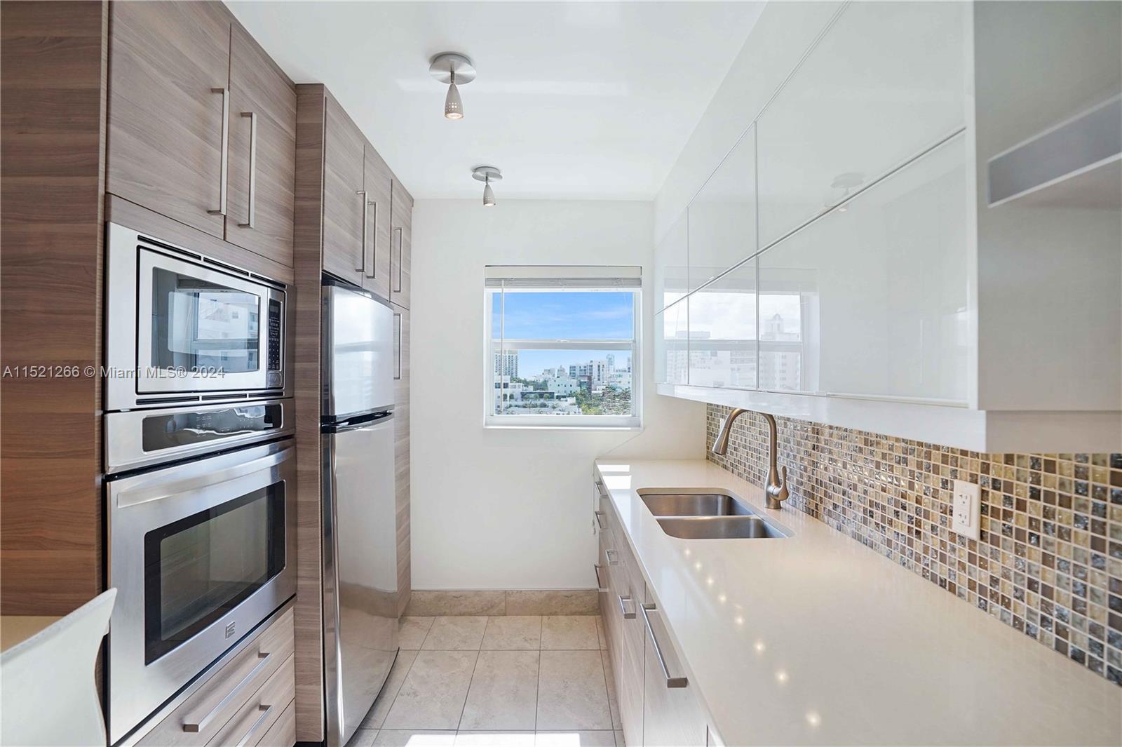 245 18th Street, Unit 902 Miami Beach, FL 33139 - Photo 30 of 54 a kitchen with stainless steel appliances a microwave a stove and a refrigerator