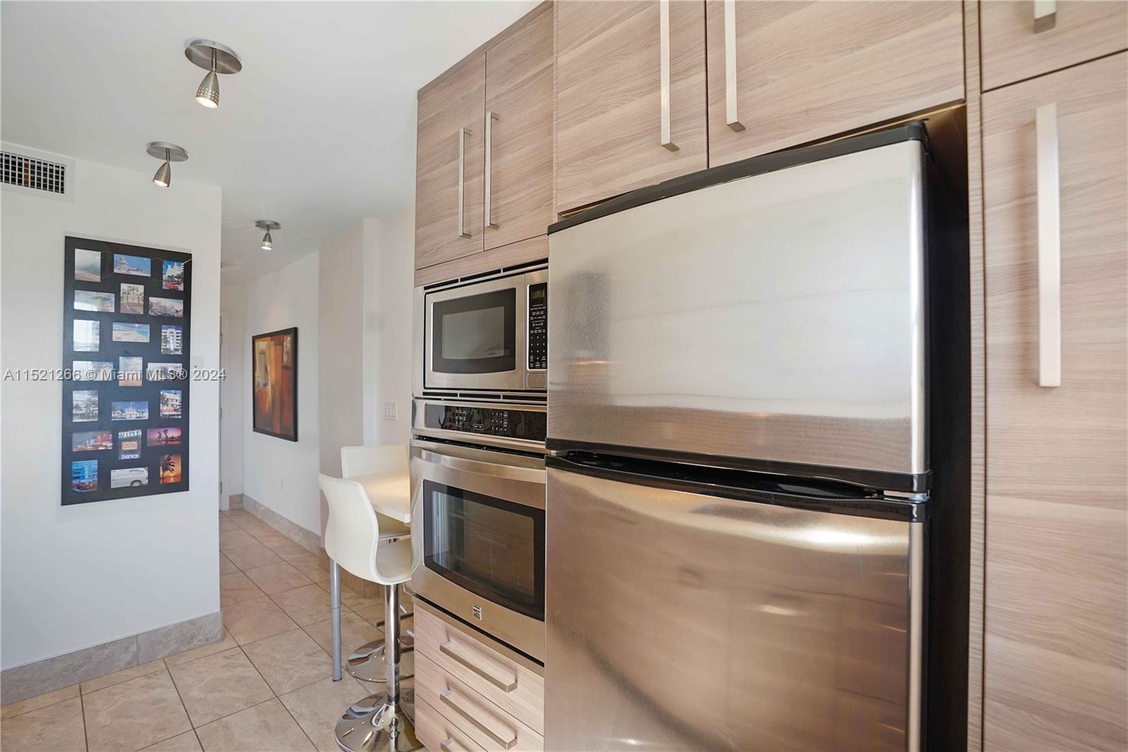 245 18th Street, Unit 902 Miami Beach, FL 33139 - Photo 32 of 54 a kitchen with stainless steel appliances a refrigerator and a stove top oven