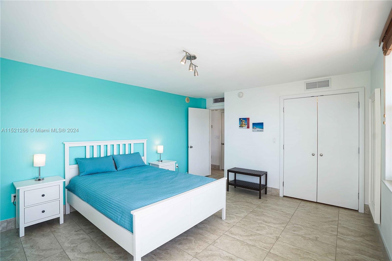 245 18th Street, Unit 902 Miami Beach, FL 33139 - Photo 38 of 54 a spacious bedroom with a bed and a chandelier