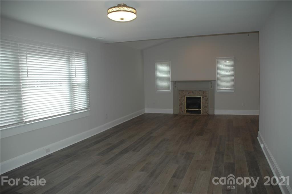 521 Gray Drive Charlotte, NC 28213 - Photo 20 of 34 an empty room with wooden floor fireplace and windows