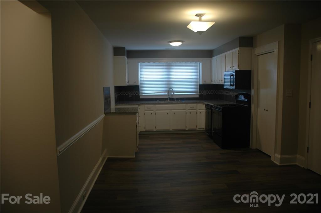 521 Gray Drive Charlotte, NC 28213 - Photo 4 of 34 a kitchen with granite countertop a stove a sink and a refrigerator