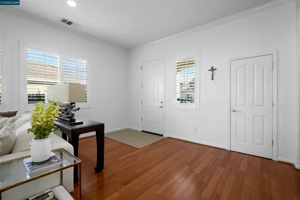 a view of a room with wooden floor a potted plant and a window