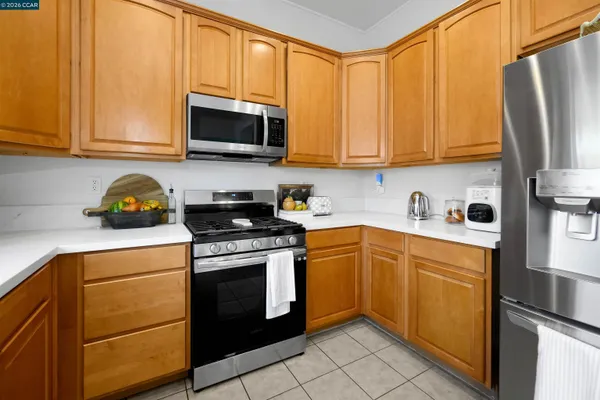 a kitchen with stainless steel appliances granite countertop a refrigerator stove top oven and sink