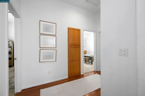 a view of hallway with wooden floor and cabinet