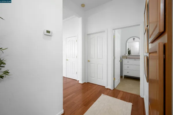 a view of a hallway with wooden floor and closet