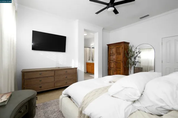 a spacious bedroom with a bed and a flat screen tv