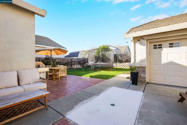 a view of a patio with a table and chairs under an umbrella