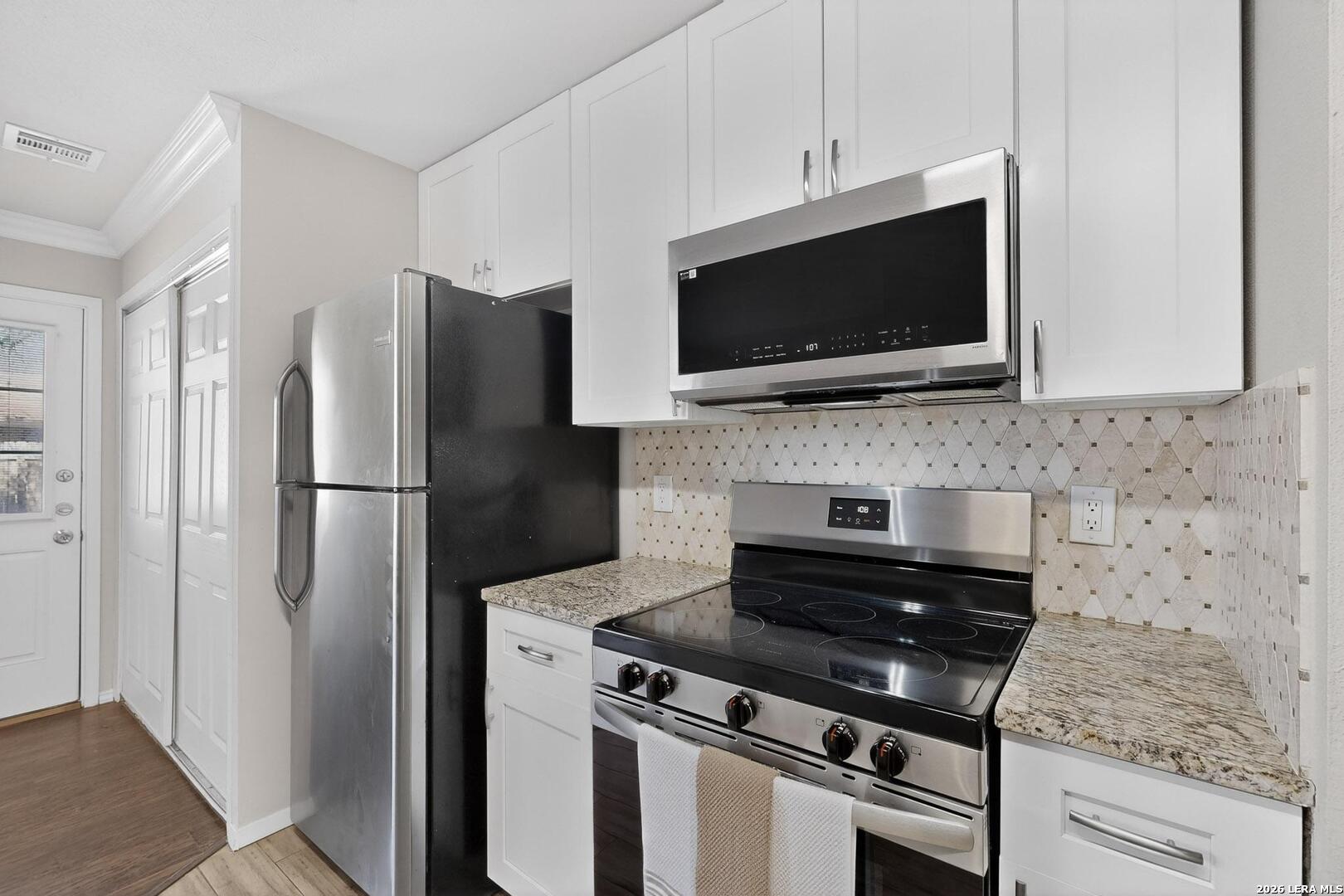 7219 Spring Drops Street San Antonio, TX 78249 - Photo 15 of 37 a kitchen with refrigerator and microwave