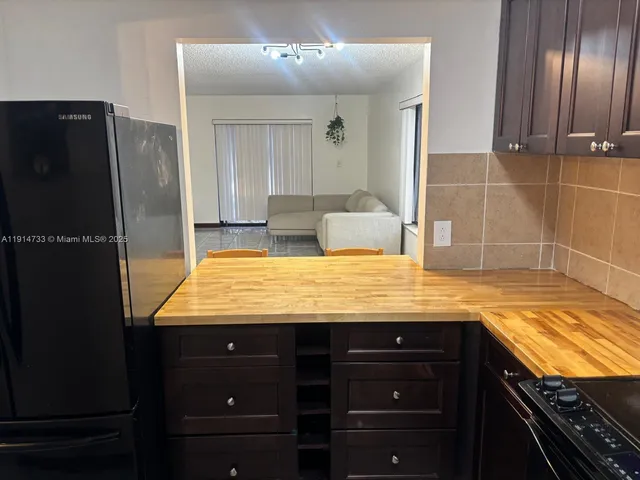 a bathroom with a granite countertop sink and a refrigerator