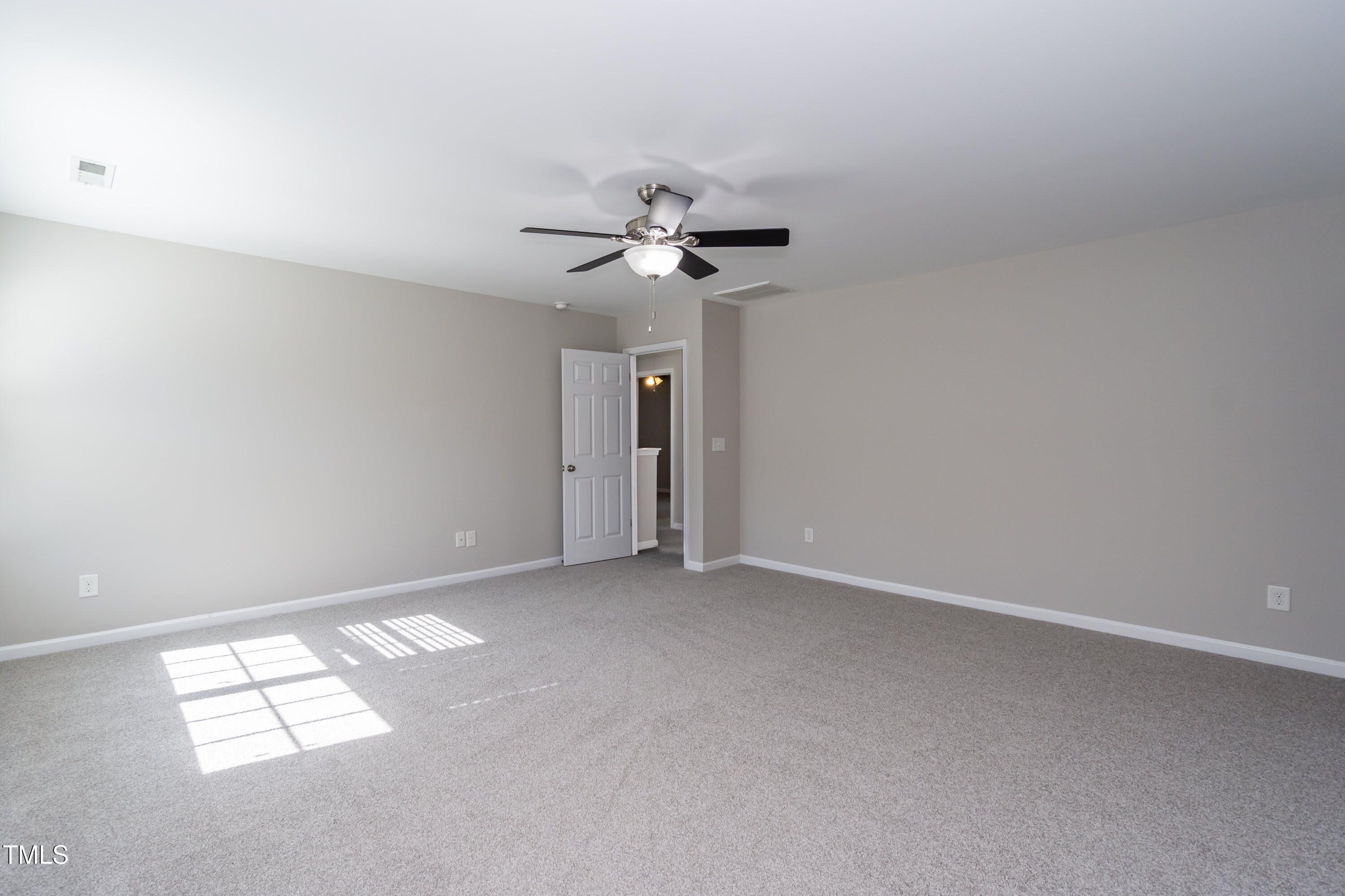 408 Cottesbrook Drive Wake Forest, NC 27587 - Photo 18 of 37 an empty room with a chandelier fan and windows