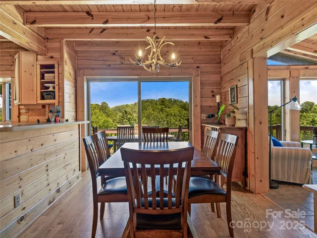 a view of a dining room with furniture a chandelier and wooden floor