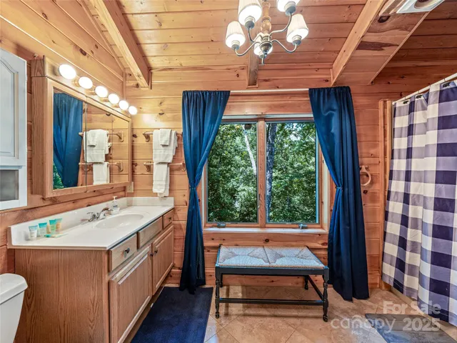 a bathroom with a sink a large window and a shower