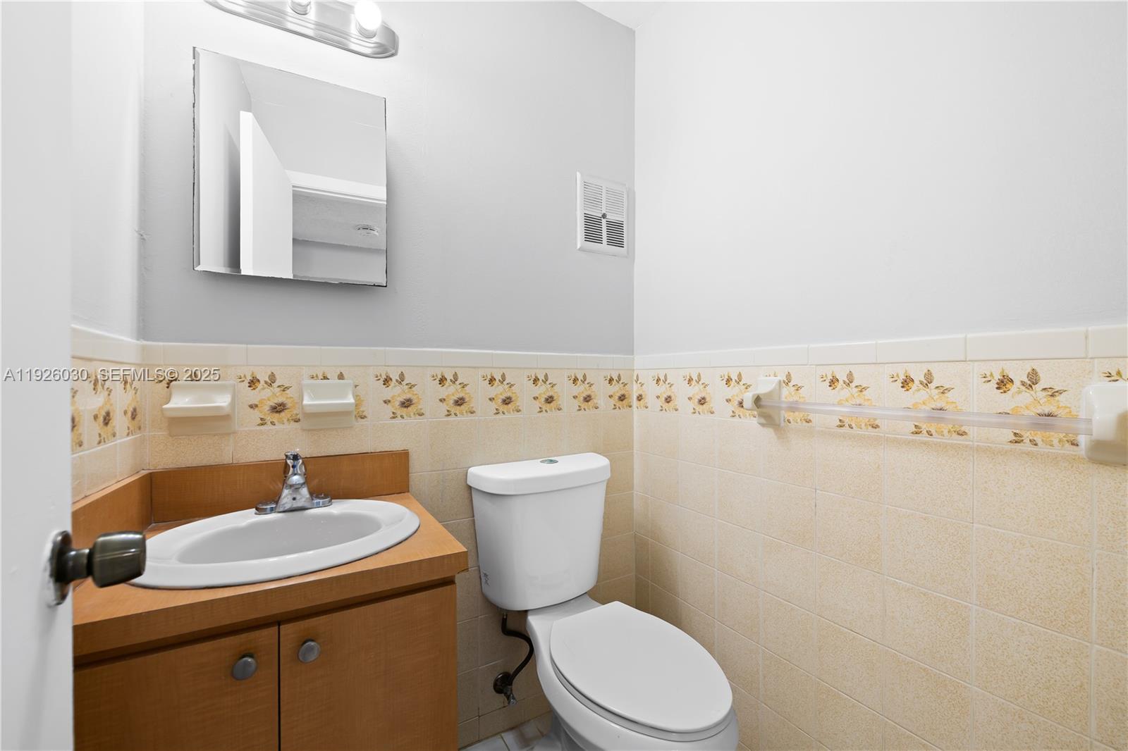 7915 Harding Avenue, Unit 1 Miami Beach, FL 33141 - Photo 12 of 25 a bathroom with a toilet sink and mirror