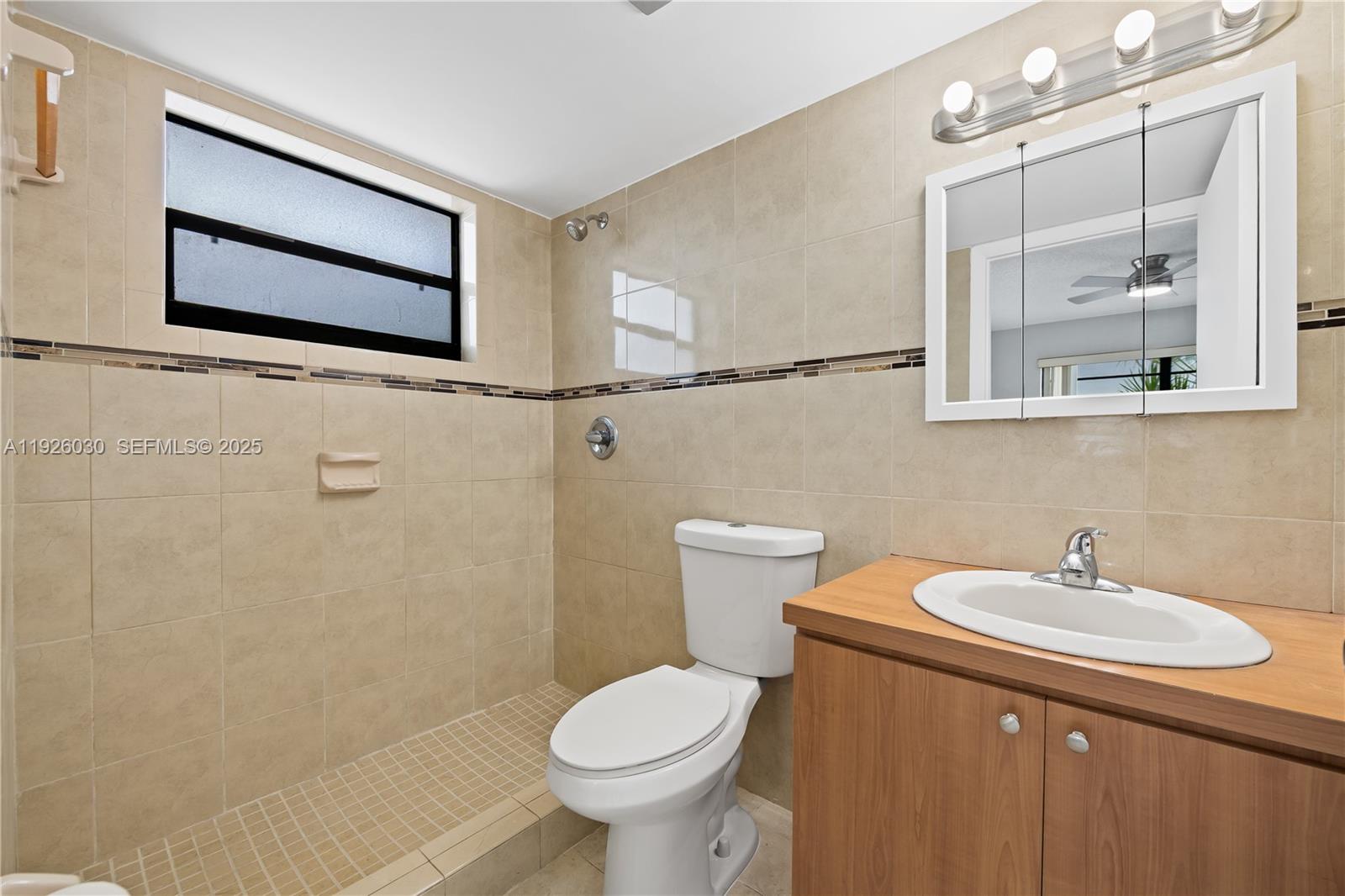 7915 Harding Avenue, Unit 1 Miami Beach, FL 33141 - Photo 17 of 25 a bathroom with a sink mirror and toilet
