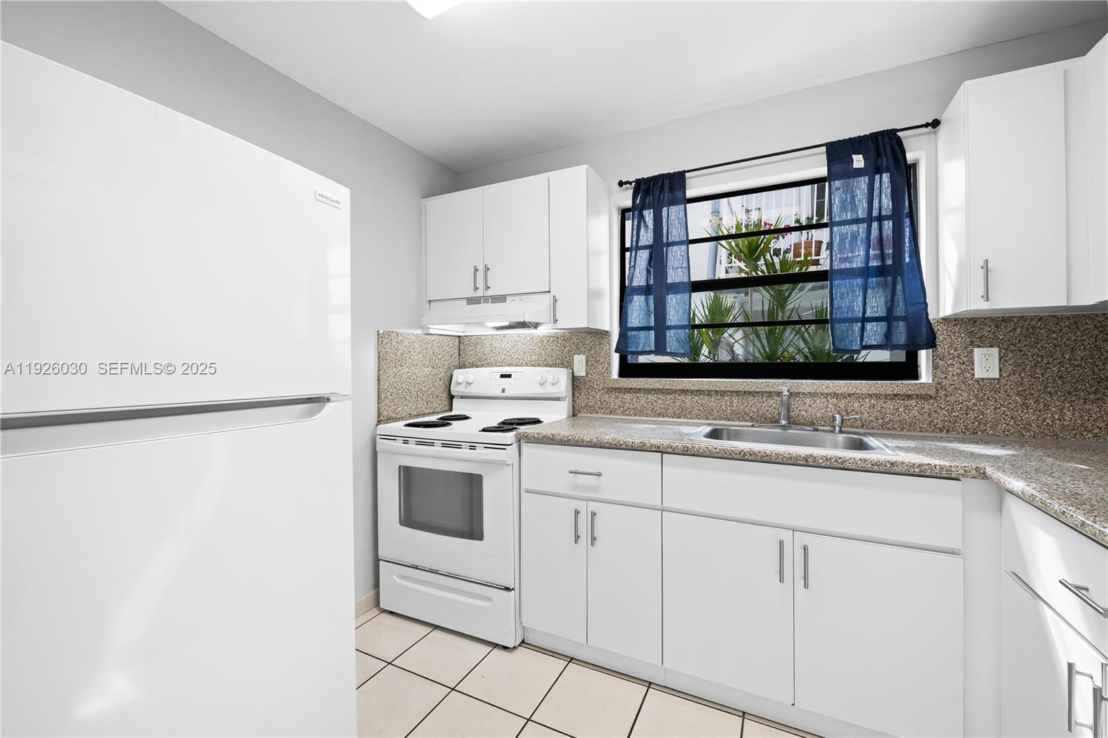 7915 Harding Avenue, Unit 1 Miami Beach, FL 33141 - Photo 9 of 25 a kitchen with a sink stove and cabinets